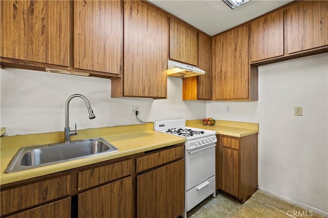 17900 Sherman Way Unit 416, Reseda, CA 91335 - kitchen featuring white range with gas stovetop, a sink, under cabinet range hood, light countertops, and brown cabinetry
