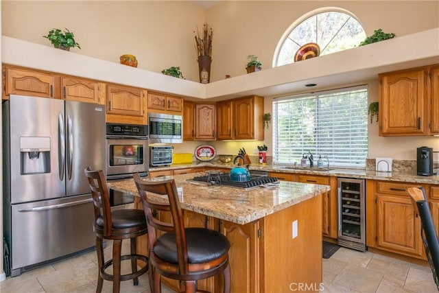 31436 Corte Sonora, Temecula, CA 92592 - kitchen with stainless steel appliances, beverage cooler, a towering ceiling, light stone counters, and a kitchen island