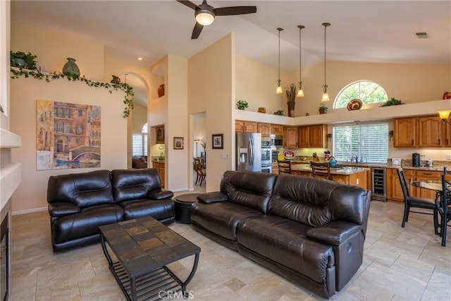 31436 Corte Sonora, Temecula, CA 92592 - living area featuring beverage cooler, ceiling fan, high vaulted ceiling, healthy amount of natural light, and light stone finish floors