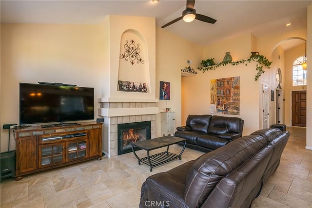 31436 Corte Sonora, Temecula, CA 92592 - living area featuring arched walkways, lofted ceiling, a ceiling fan, stone tile floors, and a tiled fireplace