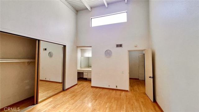 445 W Duarte Rd Unit 5, Arcadia, CA 91007 - unfurnished bedroom with a towering ceiling, light wood-style flooring, a closet, built in study area, and beam ceiling