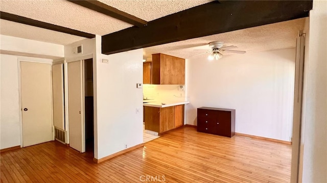 445 W Duarte Rd Unit 5, Arcadia, CA 91007 - kitchen featuring brown cabinets, ceiling fan, light wood-style floors, light countertops, and beamed ceiling