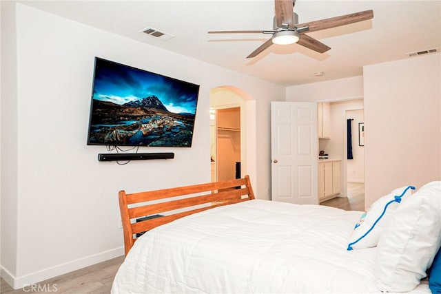 382 Settlers Rd, Upland, CA 91786 - bedroom featuring baseboards, light wood-type flooring, arched walkways, a ceiling fan, and a spacious closet