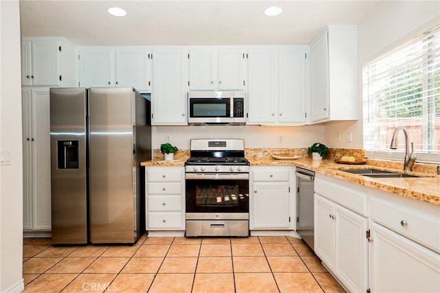 382 Settlers Rd, Upland, CA 91786 - kitchen featuring appliances with stainless steel finishes, a sink, light stone countertops, white cabinets, and light tile patterned floors
