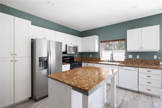 31460 Tulette Ln, Winchester, CA 92596 - kitchen with appliances with stainless steel finishes, a sink, light wood finished floors, white cabinets, and a kitchen island