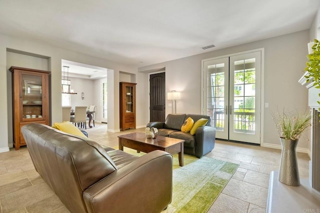 3522 Camino Cereza, Carlsbad, CA 92009 - living area with stone tile flooring, french doors, baseboards, and a chandelier