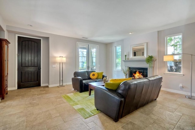 3522 Camino Cereza, Carlsbad, CA 92009 - living room featuring light stone finish flooring, a glass covered fireplace, baseboards, and healthy amount of natural light