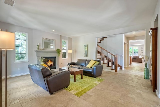 3522 Camino Cereza, Carlsbad, CA 92009 - living area featuring stairway, a glass covered fireplace, stone tile flooring, and baseboards