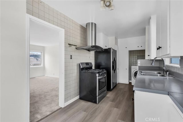 14403 S White Ave, Compton, CA 90221 - kitchen featuring appliances with stainless steel finishes, exhaust hood, a sink, white cabinetry, and washer / dryer