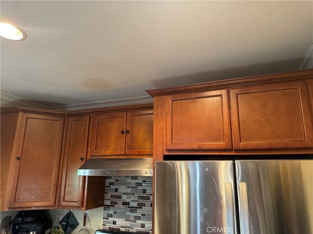 19549 Schoolcraft St, Reseda, CA 91335 - kitchen view of freestanding refrigerator, under cabinet range hood, brown cabinetry, and decorative backsplash