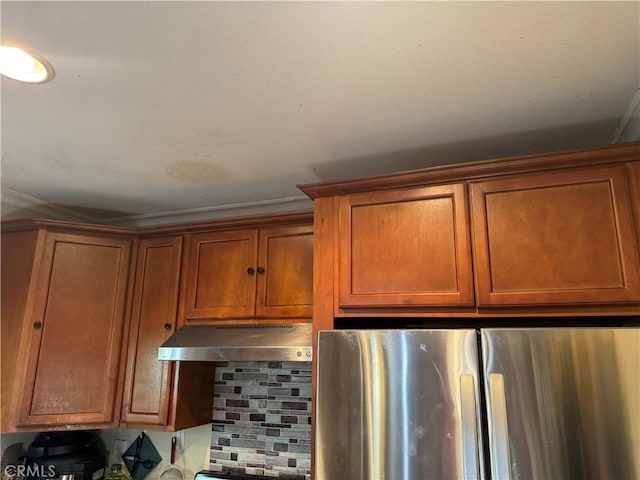 19549 Schoolcraft St, Reseda, CA 91335 - kitchen view of freestanding refrigerator, under cabinet range hood, brown cabinetry, and decorative backsplash