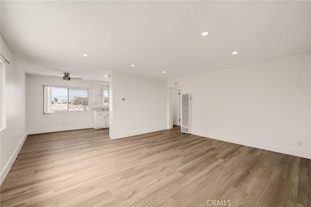 11726 Freeman Ave Unit A, Hawthorne, CA 90250 - unfurnished living room featuring a textured ceiling, a heating unit, light wood-style floors, recessed lighting, and ceiling fan