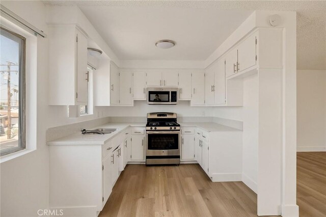 11726 Freeman Ave Unit A, Hawthorne, CA 90250 - kitchen featuring stainless steel appliances, light wood-type flooring, white cabinetry, and light countertops