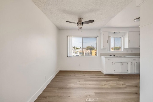 11726 Freeman Ave Unit A, Hawthorne, CA 90250 - unfurnished dining area featuring a textured ceiling, light wood finished floors, a ceiling fan, and baseboards