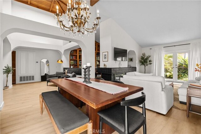 24232 Porto Nuovo, Dana Point, CA 92629 - dining room featuring arched walkways, high vaulted ceiling, light wood-style flooring, and built in features