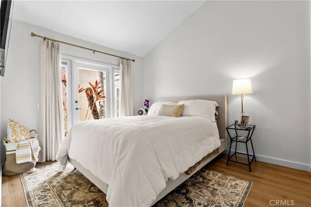 24232 Porto Nuovo, Dana Point, CA 92629 - bedroom featuring access to exterior, vaulted ceiling, wood finished floors, and baseboards
