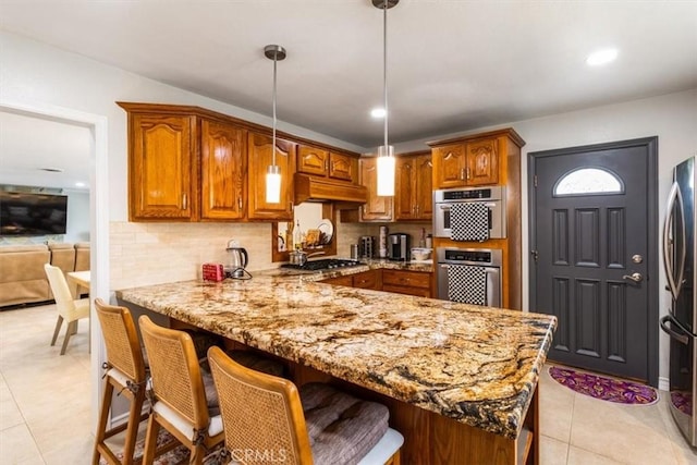 19921 Rambling Rd, Covina, CA 91724 - kitchen with appliances with stainless steel finishes, brown cabinets, a peninsula, light stone countertops, and tasteful backsplash