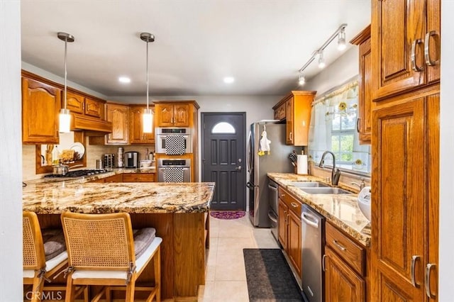 19921 Rambling Rd, Covina, CA 91724 - kitchen featuring a sink, stainless steel appliances, a peninsula, light stone counters, and a breakfast bar