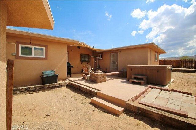 1910 Artesia Ave, Landers, CA 92285 - rear view of house featuring a hot tub, a patio area, and stucco siding