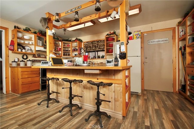 1910 Artesia Ave, Landers, CA 92285 - kitchen featuring open shelves, wallpapered walls, freestanding refrigerator, dark wood-style floors, and a breakfast bar area
