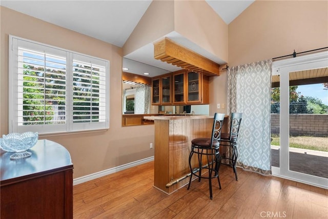 1214 Mallorca St, Upland, CA 91784 - indoor wet bar with vaulted ceiling, baseboards, plenty of natural light, and wood finished floors
