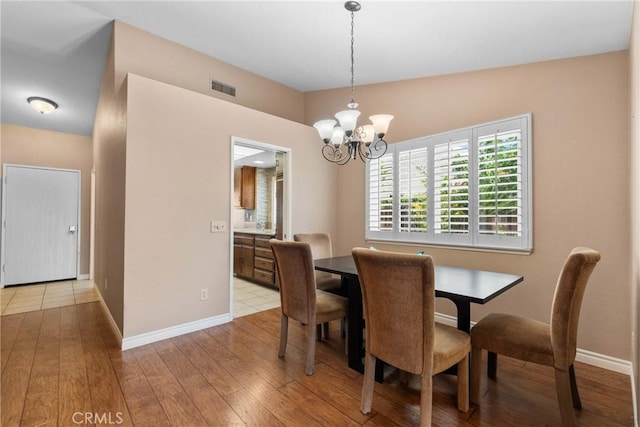 1214 Mallorca St, Upland, CA 91784 - dining area featuring a chandelier, light wood finished floors, and baseboards