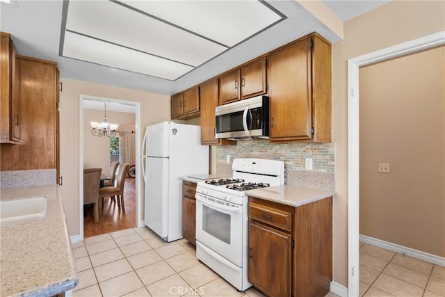 1214 Mallorca St, Upland, CA 91784 - kitchen featuring white appliances, light tile patterned flooring, a chandelier, and tasteful backsplash