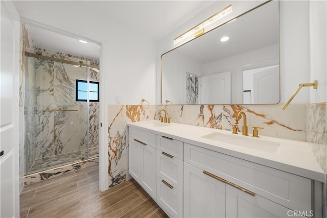 22011 La Puente Rd, Walnut, CA 91789 - bathroom featuring double vanity, a marble finish shower, wood finished floors, tile walls, and recessed lighting