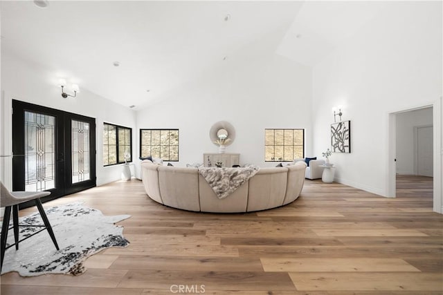 22011 La Puente Rd, Walnut, CA 91789 - living room featuring high vaulted ceiling, french doors, light wood-style floors, and baseboards