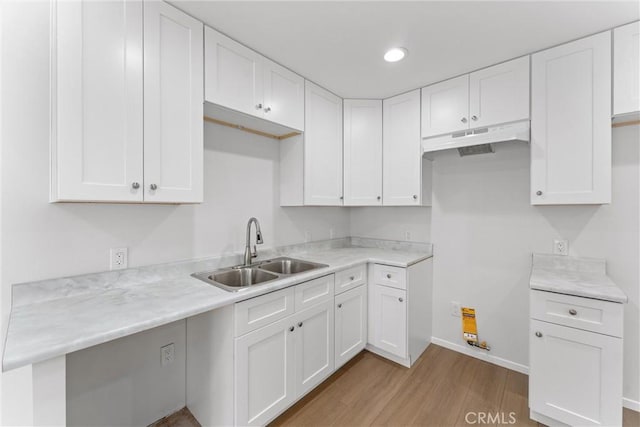 1121 S Dover Cir Unit C44K, Anaheim, CA 92805 - kitchen featuring a sink, under cabinet range hood, light wood-type flooring, white cabinetry, and light countertops