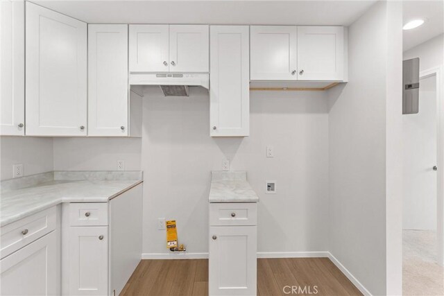 1121 S Dover Cir Unit C44K, Anaheim, CA 92805 - kitchen featuring light wood-style flooring, white cabinets, light countertops, and baseboards