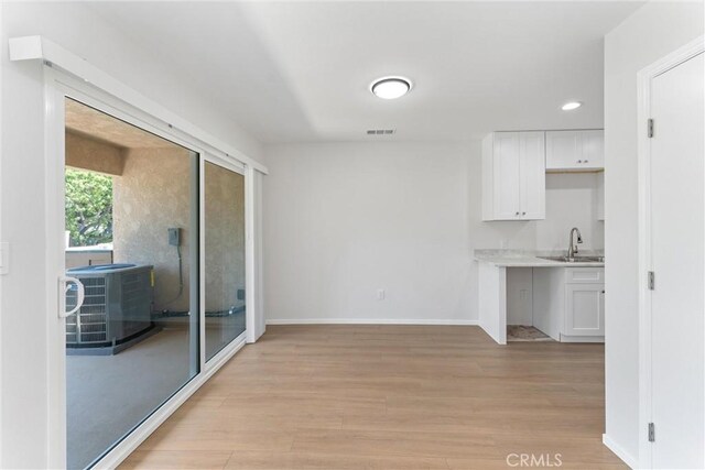1121 S Dover Cir Unit C44K, Anaheim, CA 92805 - unfurnished dining area with a sink, light wood-style flooring, baseboards, and recessed lighting