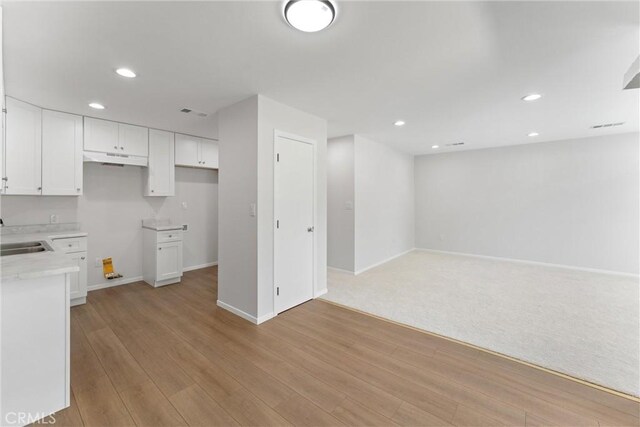 1121 S Dover Cir Unit C44K, Anaheim, CA 92805 - kitchen featuring white cabinetry, a sink, recessed lighting, light countertops, and light wood finished floors