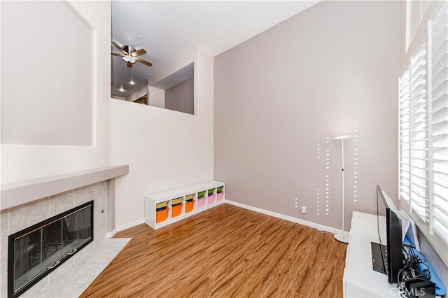 4536 Montecito Dr, La Palma, CA 90623 - unfurnished living room with wood finished floors, ceiling fan, a tile fireplace, and baseboards