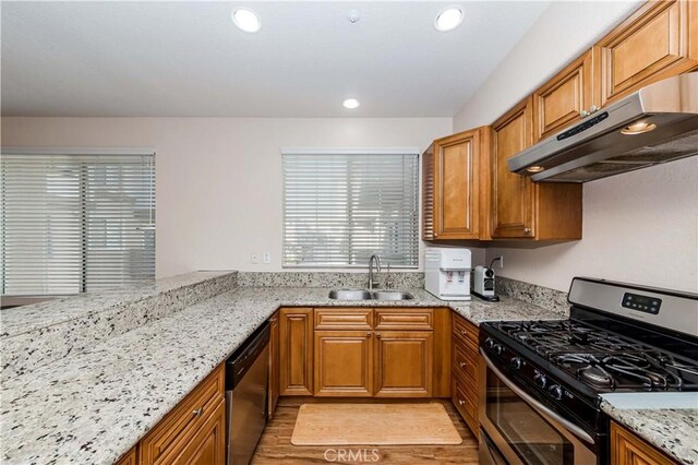 4536 Montecito Dr, La Palma, CA 90623 - kitchen with appliances with stainless steel finishes, a sink, under cabinet range hood, brown cabinets, and recessed lighting