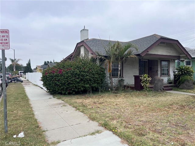 1903 E 59th St, Long Beach, CA 90805 - view of side of property featuring a chimney, a shingled roof, and a porch