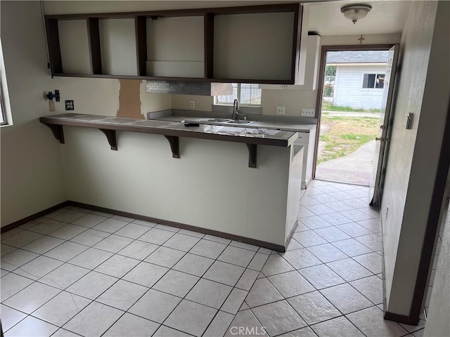 1903 E 59th St, Long Beach, CA 90805 - kitchen with a sink, a breakfast bar, baseboards, and light tile patterned floors