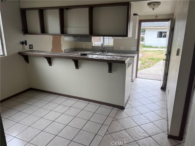 1903 E 59th St, Long Beach, CA 90805 - kitchen featuring a sink, a kitchen bar, and baseboards