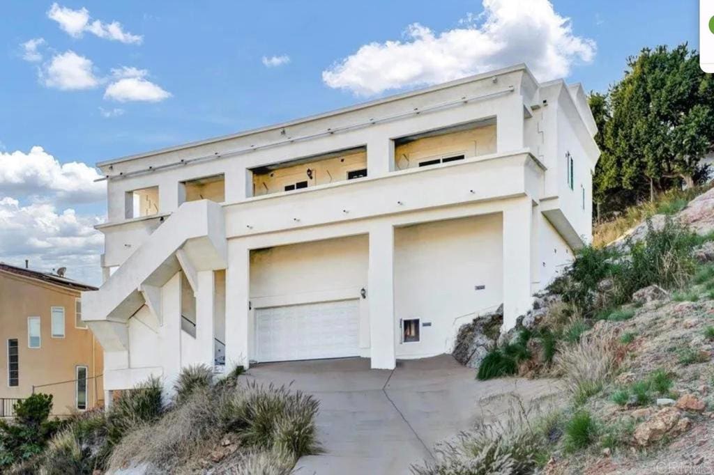 1606 Sangamon Ave, Spring Valley, CA 91977 - view of front of house featuring stucco siding, concrete driveway, a balcony, and a garage