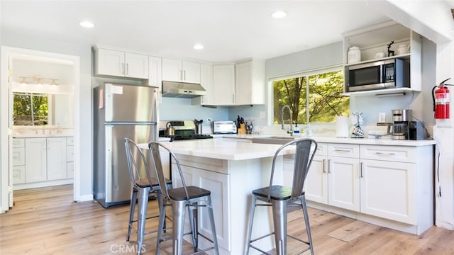 27638 St Bernard Ln, Lake Arrowhead, CA 92352 - kitchen featuring freestanding refrigerator, stainless steel microwave, under cabinet range hood, range, and white cabinets