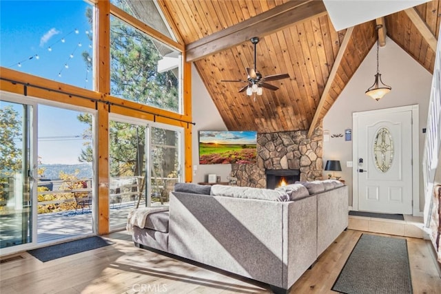 27638 St Bernard Ln, Lake Arrowhead, CA 92352 - living room with high vaulted ceiling, wood finished floors, ceiling fan, a stone fireplace, and a wood ceiling with exposed beams