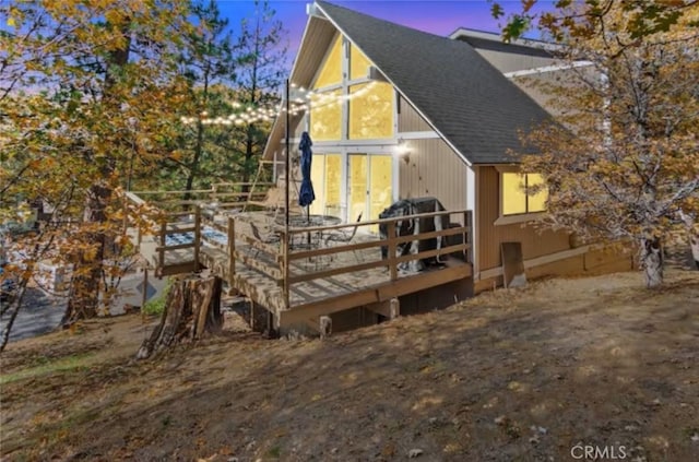 27638 St Bernard Ln, Lake Arrowhead, CA 92352 - back of property at dusk featuring a deck and roof with shingles