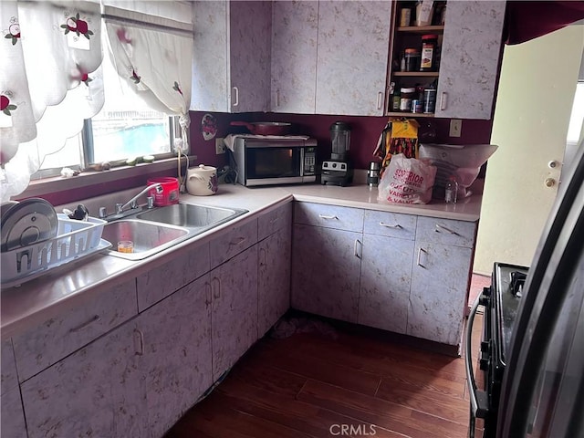 1909 E 59th St, Long Beach, CA 90805 - kitchen with stainless steel microwave, dark wood-type flooring, a sink, light countertops, and gas range