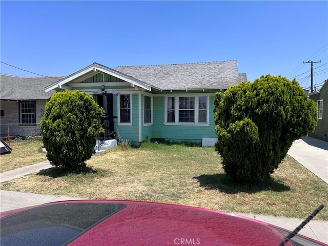 1909 E 59th St, Long Beach, CA 90805 - view of front of house with a front yard and roof with shingles