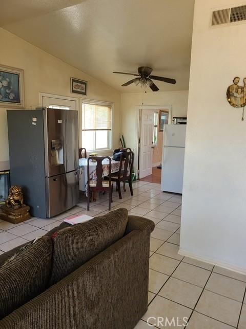 14680 Upland Ave, Fontana, CA 92335 - living room featuring light tile patterned floors, ceiling fan, and vaulted ceiling