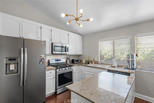 5463 Newcastle Ave Unit 8, Encino, CA 91316 - kitchen featuring appliances with stainless steel finishes, a sink, a chandelier, white cabinetry, and vaulted ceiling
