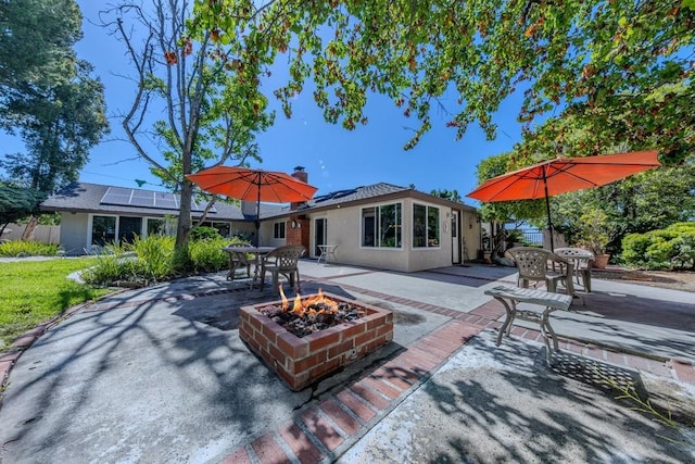 18269 Laurel View Dr, Yorba Linda, CA 92886 - rear view of property featuring a fire pit, a patio area, roof mounted solar panels, outdoor dining area, and stucco siding