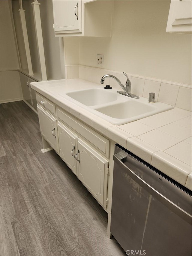 2119 Via Puerta Unit Q, Laguna Woods, CA 92637 - kitchen featuring dishwasher, a sink, dark wood-style floors, white cabinets, and light countertops