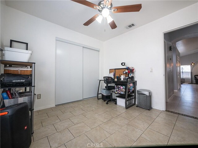 1173 Conestoga St, Corona, CA 92881 - home office featuring arched walkways, a ceiling fan, light tile patterned floors, and baseboards