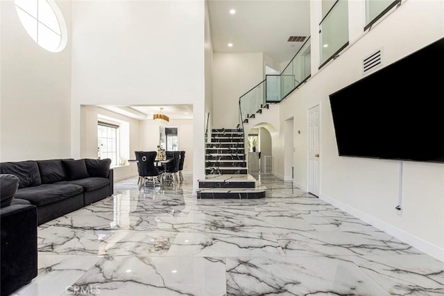 20128 Cavern Ct, Saugus, CA 91390 - living area with a towering ceiling, marble tiled floors, arched walkways, stairs, and baseboards